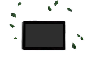 Screen tablet computer and leaf on white background. Flatlay.
