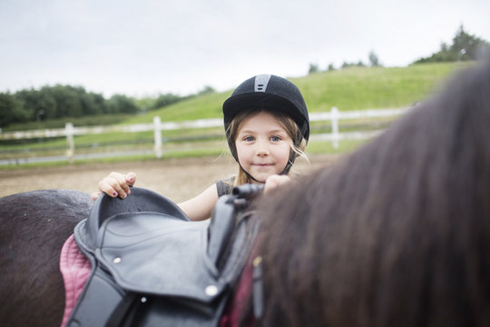 Portrait of girl (4-5) behind pony