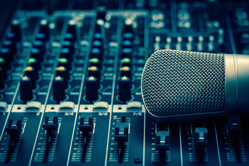 Closeup microphone over the audio mixer, vintage film style, music equipment concept