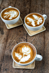 Top view of coffee cup set which consist of latte art and capuchino ooer the wooden table, drink and coffee shop concept