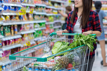 Closeup Young Asian women Hand holding the trolley for shopping over the store blurred in...