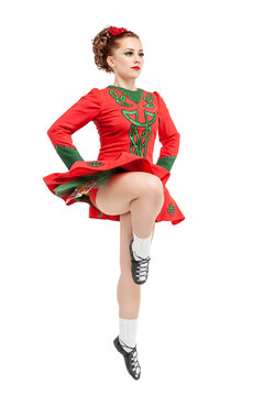 Beautiful woman in red dress for Irish dance jumping isolated