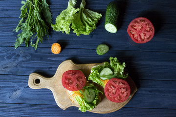 The sandwiches with vegetables on a board. Vegetarian food. Ingredients for cooking on the table.