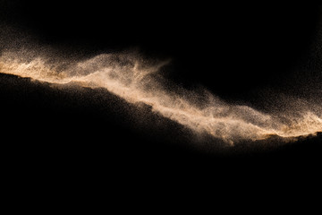 Golden sand explosion isolated on black background. Abstract sand cloud. Golden colored sand splash...