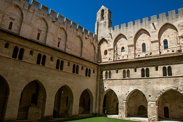 Fototapeta premium View of courtyard and internal buildings of the Palace of the Popes of Avignon, under a sunny blue sky. Located in the Vaucluse department, Provence-Alpes-Côte d'Azur region, southeastern France
