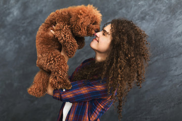 Studio shot of happy woman with cute curly dog