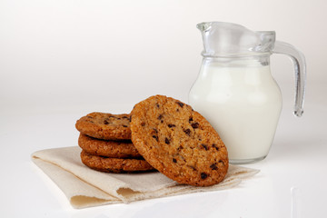 Dairy milk with home made cookies over white background