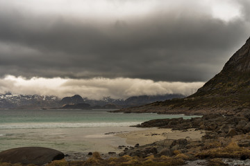 Rorvikstranda beach and Gimsoystraumen fjord near Henningsvaer at Lofoten Islands / Norway at a rainy day