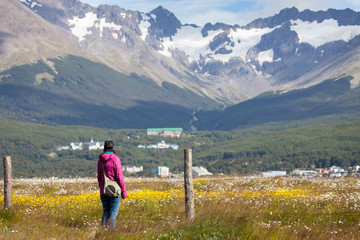 Fototapeta na wymiar Woman in purple jackget looking over a mountain landscape