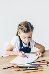 cute little child drawing with color pencils isolated on white