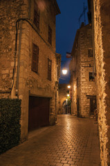 Fototapeta na wymiar Night view of alley with lamp in the Vence village, a stunning medieval town completely preserved. Alpes-Maritimes department, Provence region, southeastern France.