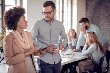 Business colleagues in modern office using tablet