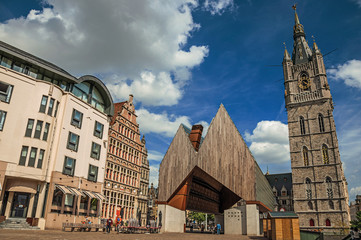 Modern building and old clock tower with clouds and blue sky in Ghent. In addition to intense...