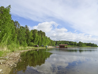 Summer landscape: blue lake on a Sunny day and sky with feathery clouds