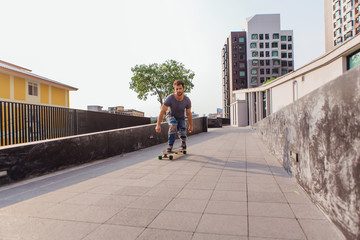 Young man riding skateboard on the street.