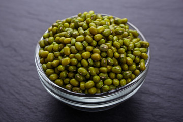 fresh Mung beans on a dark stone background