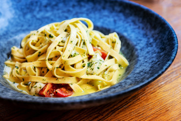 Pasta with pesto sauce and nuts on a the table