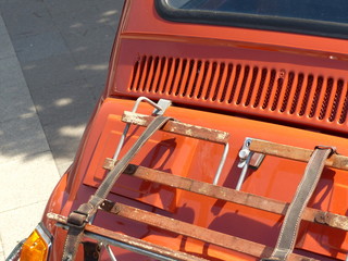 Kleinwagen aus Italien der Siebzigerjahre im zeitgenössischen Orange mit Heckgepäckträger und...