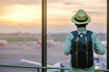 Young man traveler with hat, Asian passenger in international airport terminal. Travel concept