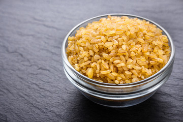 raw bulgur on a dark stone background