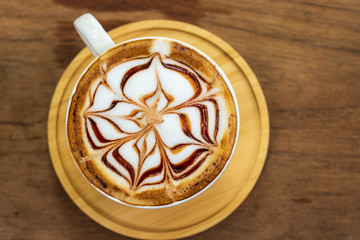 Top view of latte art coffee cup on wooden table