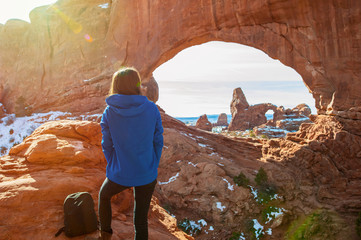 Young woman traveler enjoying the natural beauty of the Double Arch rock formation in Arches National Park.