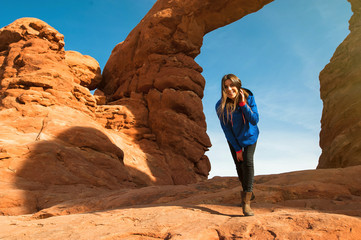 Young woman traveler with backpack hiking the Turret Arch, Arches National Park in Utah © vladteodor