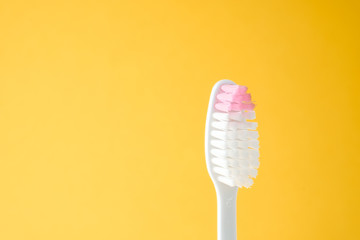 Close-up plastic toothbrushes head isolated on yellow background