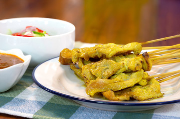 Pork Satay with peanut sauce and vegetables salad sauce on napery cloth