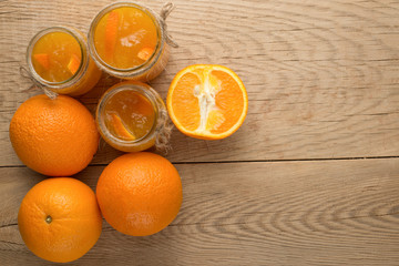 Orange jam in a glass jar on a wooden background.With blank space for writing