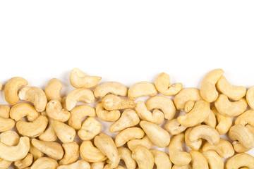 Border of raw, organic, whole cashew nut kernels over white