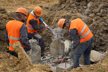 workers at the construction site chop a jackhammer piles are cut down hollow concrete