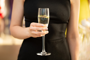 woman holding glass of champagne and toasting, happy festive moment