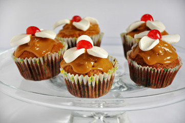 Muffins with caramel and sweet foam on a light background