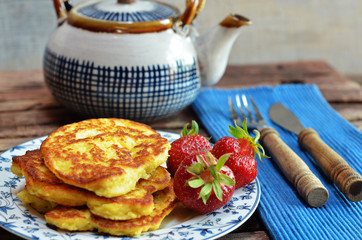 Pancakes with apples on a plate on a wooden background