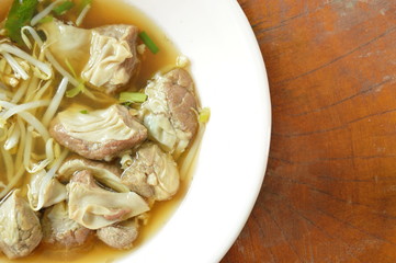 braised pork and bean sprout in brown soup on bowl