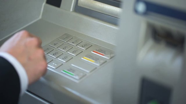 Man entering pin code, making mistake and pressing correction button on ATM