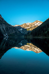 Fototapeta na wymiar Spiegelungen im Bergsee vor den Alpen
