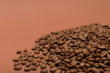 Grains of coffee on a brown background.