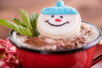 christmas concept snowman cookie in hot cocoa chocolate red mug