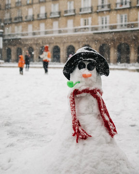 Small snowman on old town street
