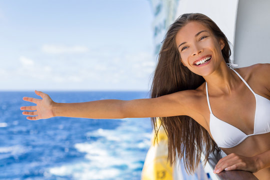 Cruise ship vacation travel fun freedom woman relaxing with open arms on sea background . Asian tourist girl on holidays feeling free on Caribbean getaway holiday.