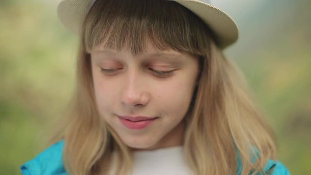 Portrait of a young beautiful woman, in the mountains in summer, eating sour green apricot