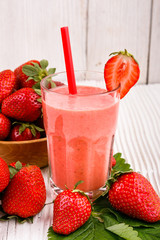 fresh strawberrysmoothie or milkshake on a wooden rustic background
