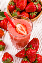 fresh strawberrysmoothie or milkshake on a wooden rustic background