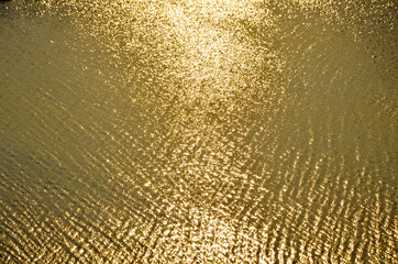 wave of a sandy beach and glare of the sun,   golden yellow  background,     texture