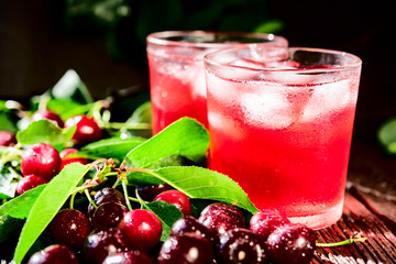 Fresh cherries and ice cherry fruit drink on wood