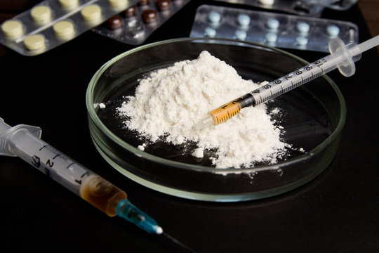 Drugs and syringes on dark table. Opioid epidemic .