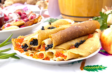 Shrovetide, pancake week, festival meal. Pancakes with red and black caviar. Rustic style.