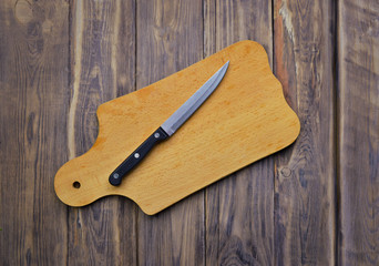 Knife and cutting board on a worn wooden fong. Top view. Cooking. Inspiration. Profession.